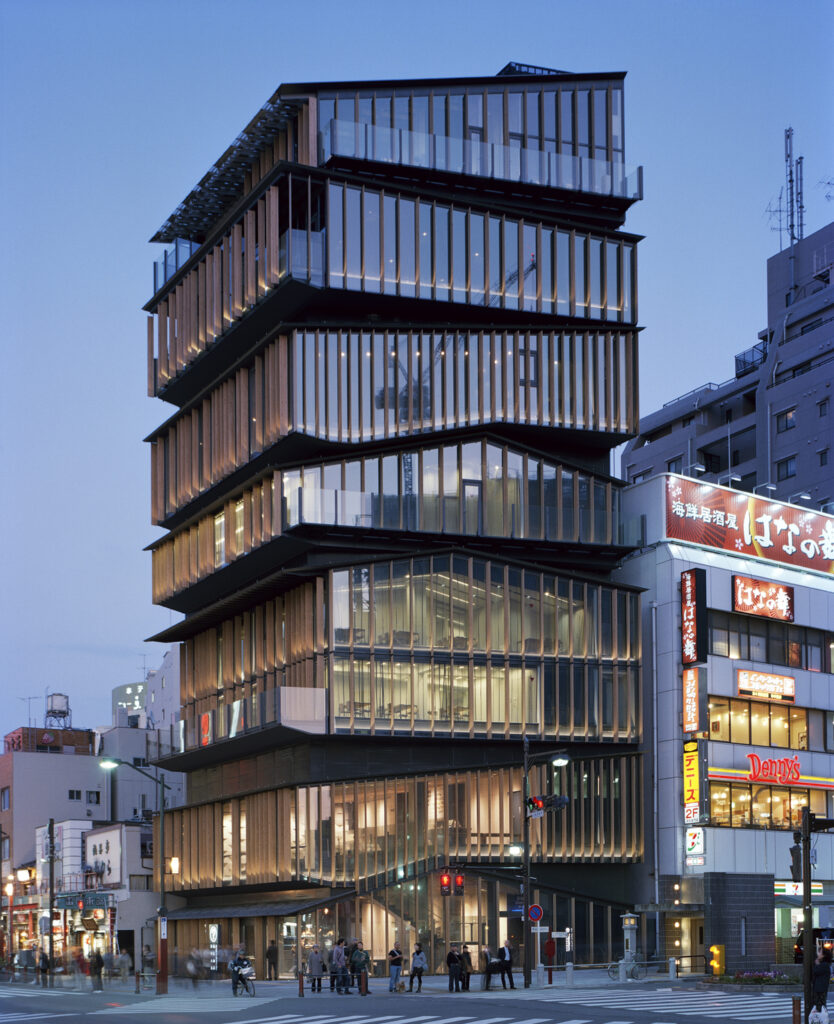 Modern eight story building made of glass windows, adorned with decorative beams
