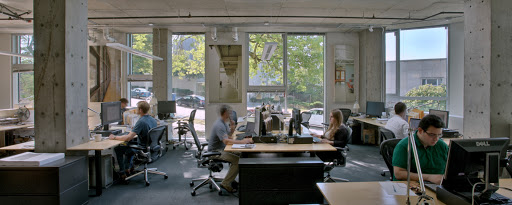 Inside an office with people sitting at tables in front of computers