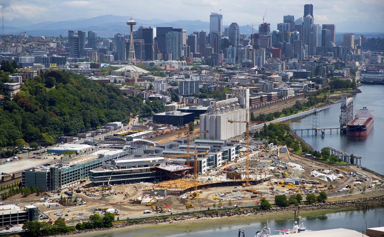 Birdseye view of construction happening at the Seattle waterfront with a view of the city in the background
