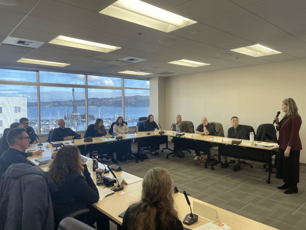 Members of research project sitting in a U shape at tables
