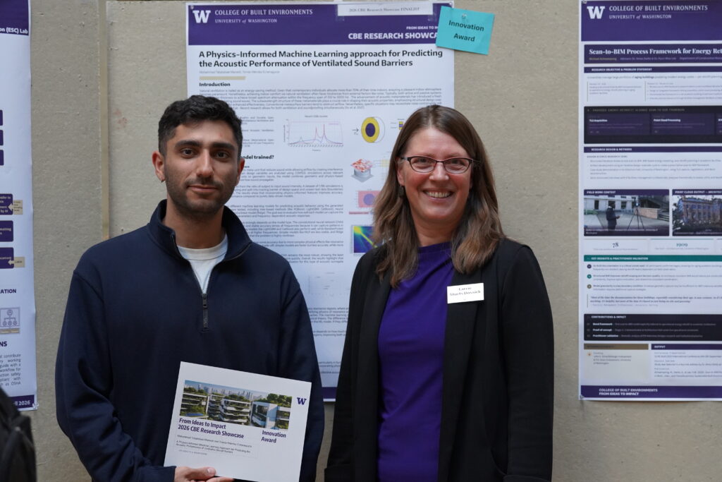 Two people smiling holding up a paper with research on it